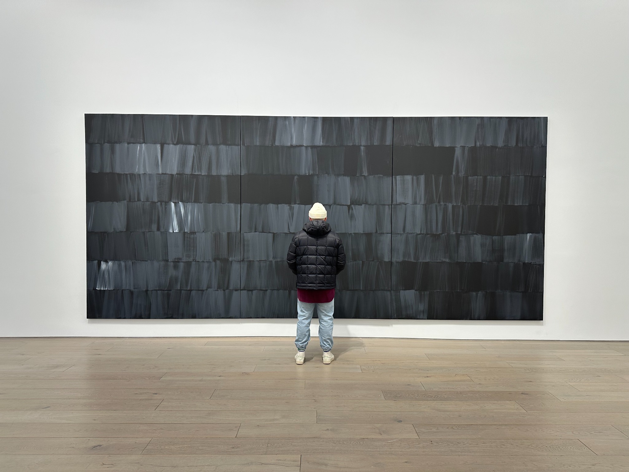 Large black triptych in a gallery